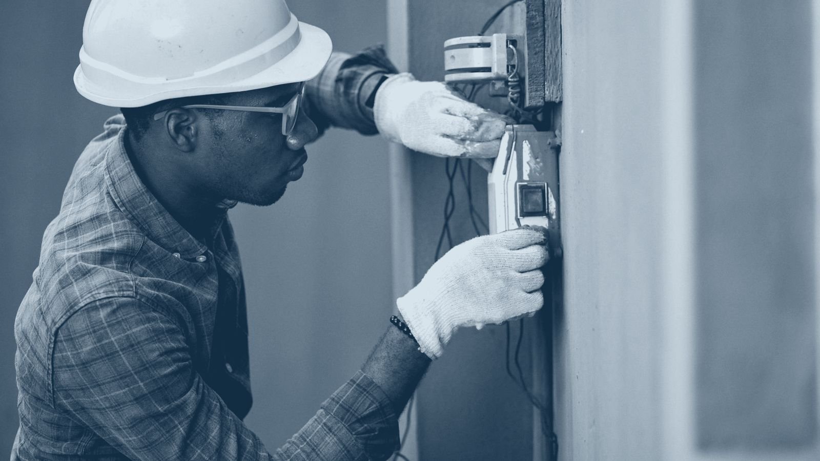A building services technician working on electrical equipment