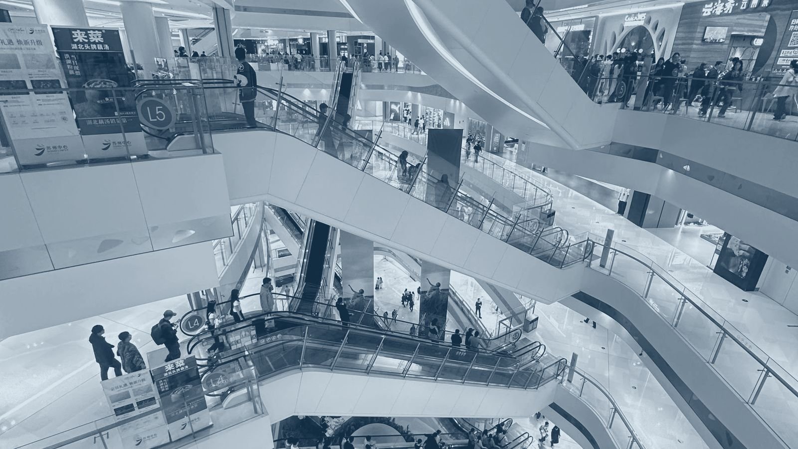 A multi level shopping mall concourse with escalators