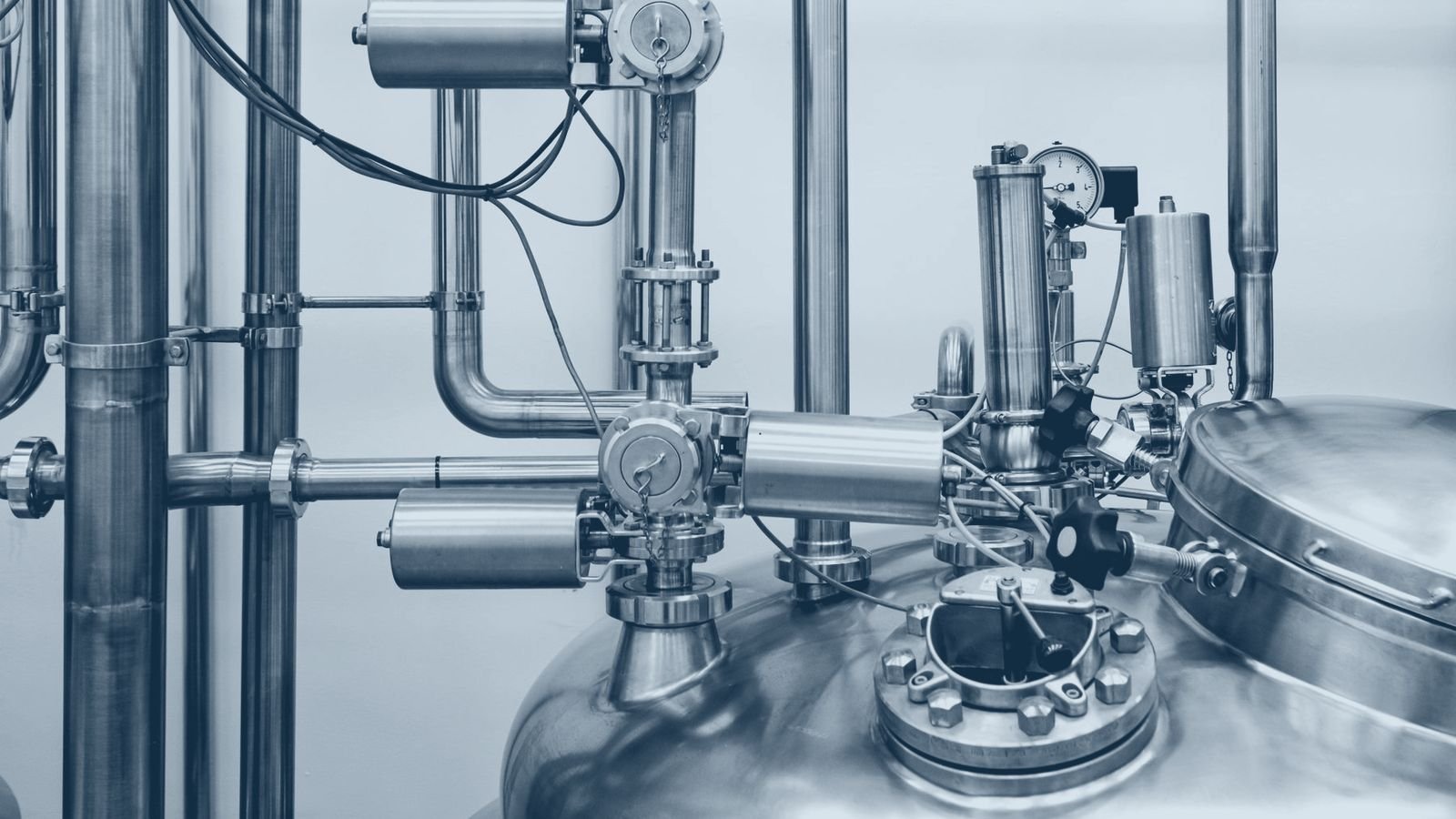 A stainless steel process vessel with valves, gauges and pipework