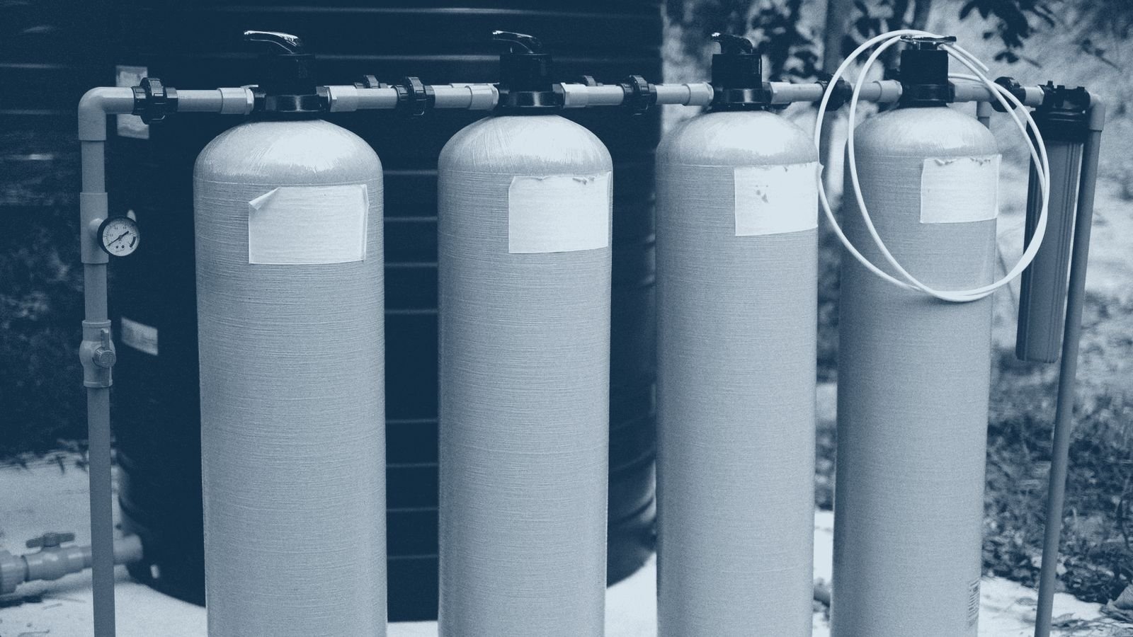 Industrial water treatment tanks connected by blue pipework